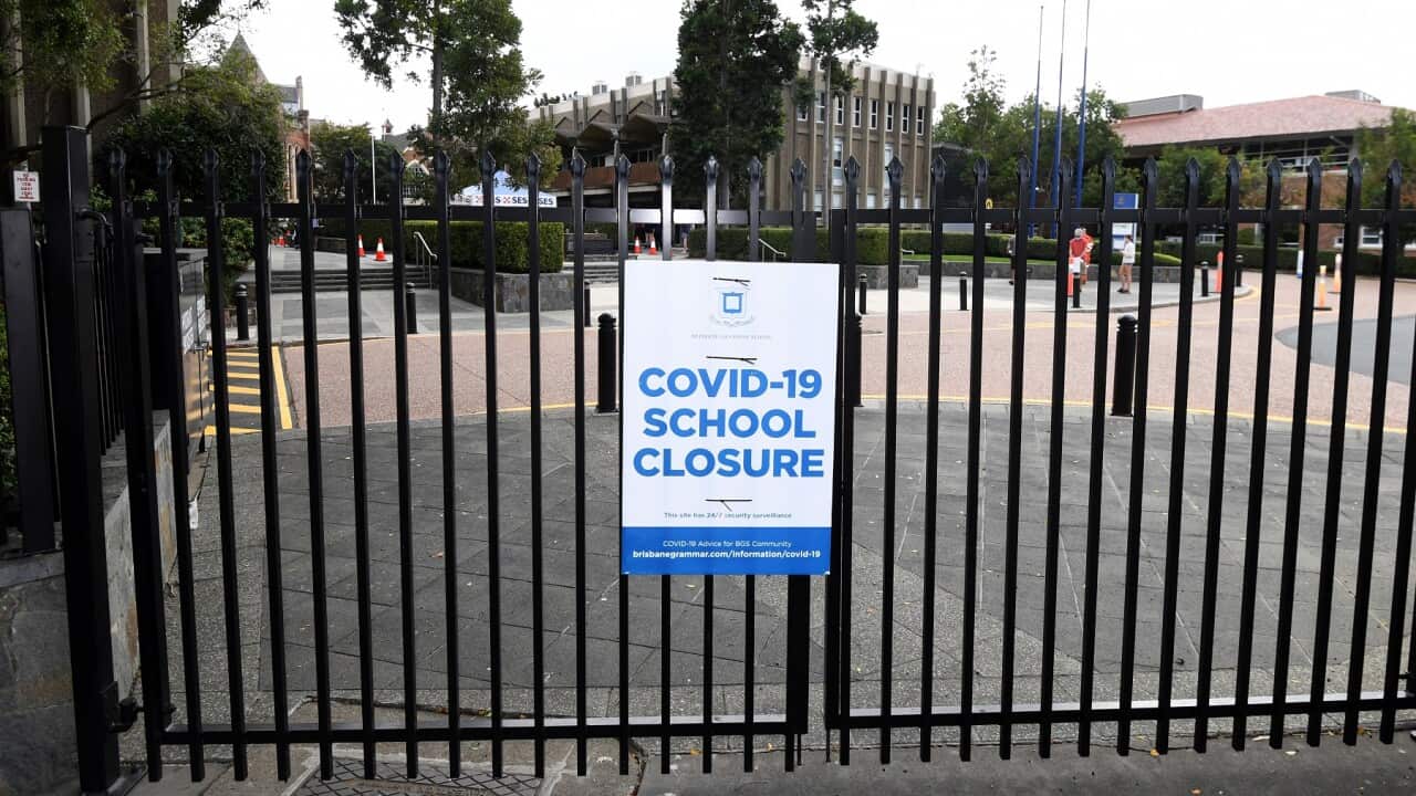 A Covid-19 closure sign on the gate of a school