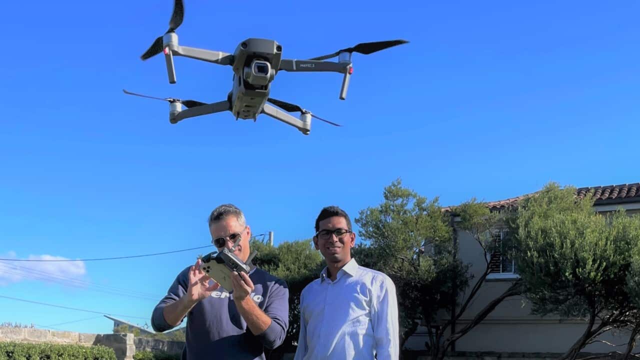 Tom Caska and Rakesh Routhu with one of their drones (SBS).jpg