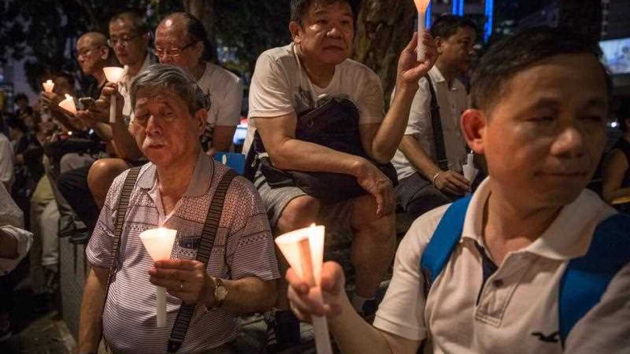 Activist hold candles during a candlelight vigil in Hong Kong