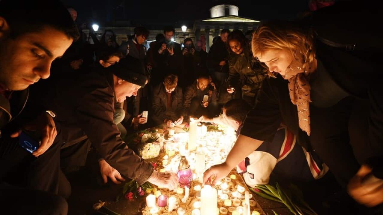 Mourners light candles at a vigil in London