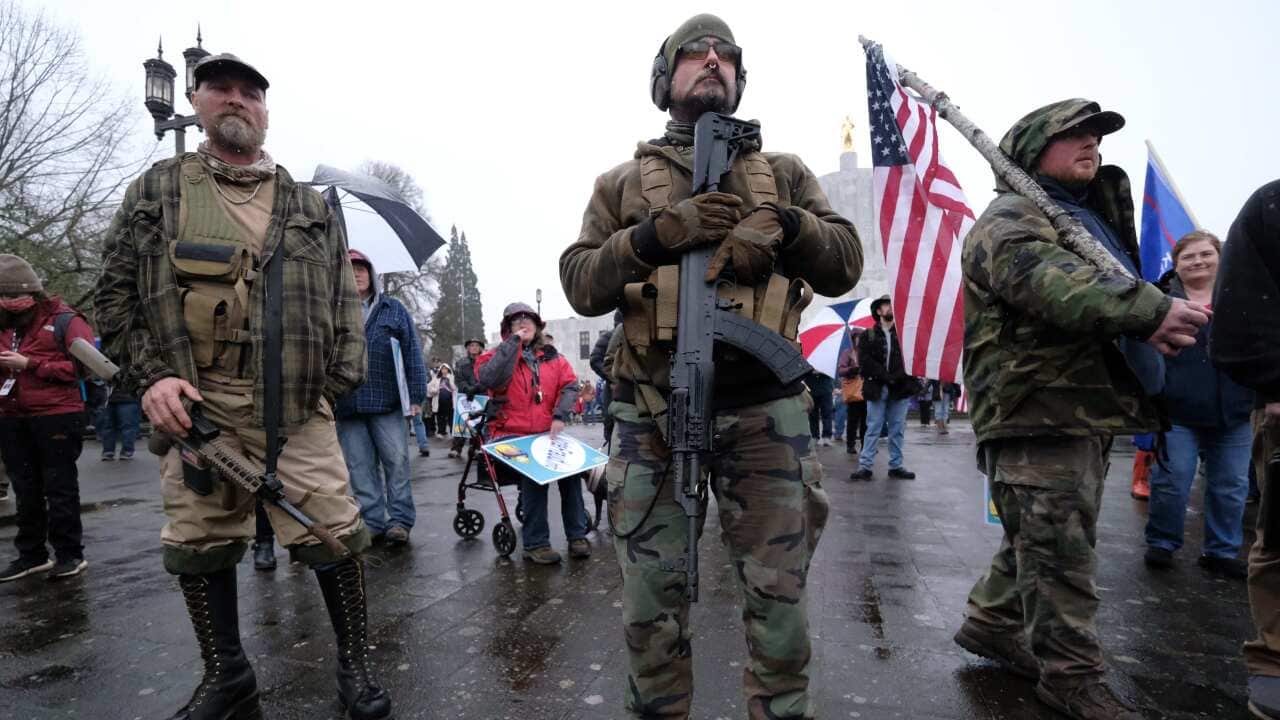 Men armed with assault rifles stand with Trump supporters outside the State Capitol in Salem, Ore., on January 6, 2021, during a Stop the Steal rally. (Photo by Alex Milan Tracy/Sipa USA)