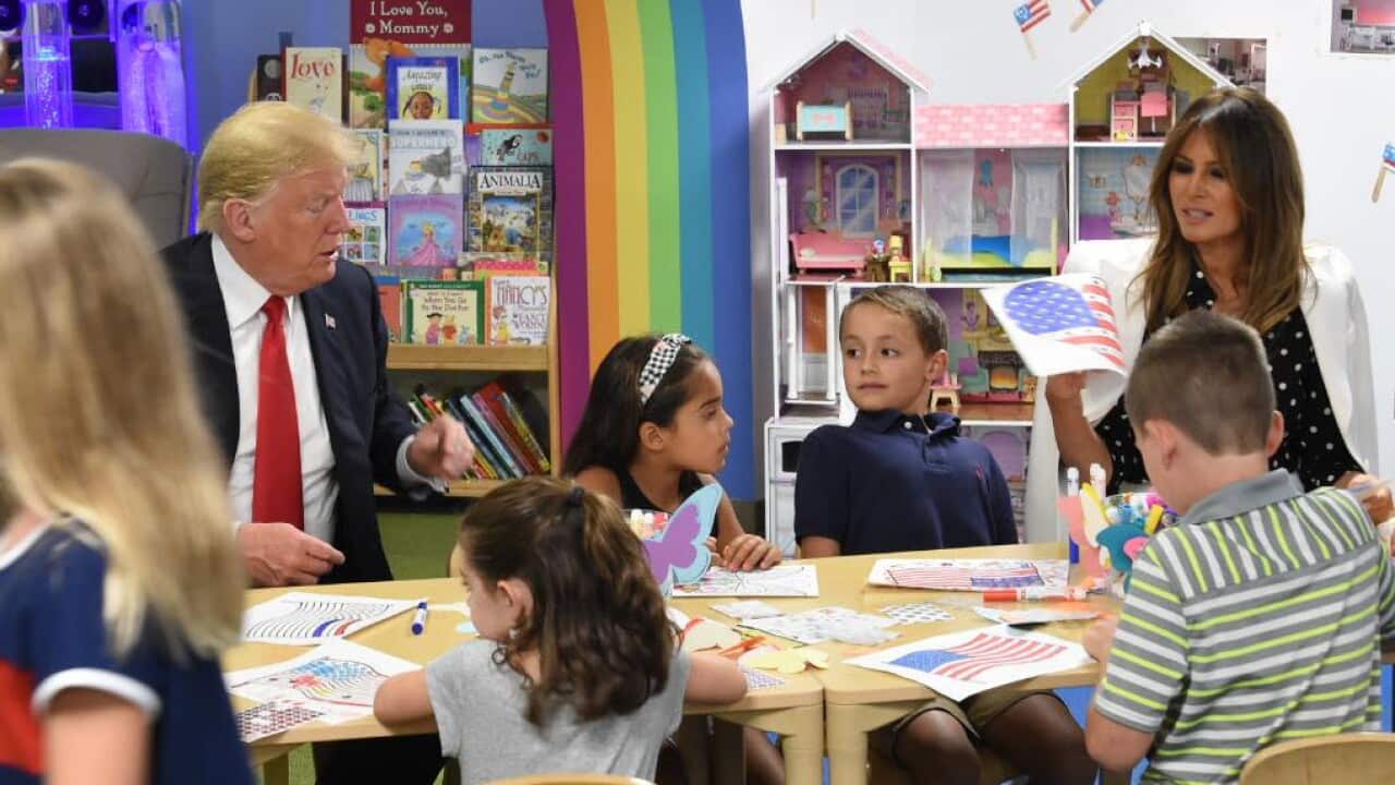 President Trump using a blue marker to colour the flag.