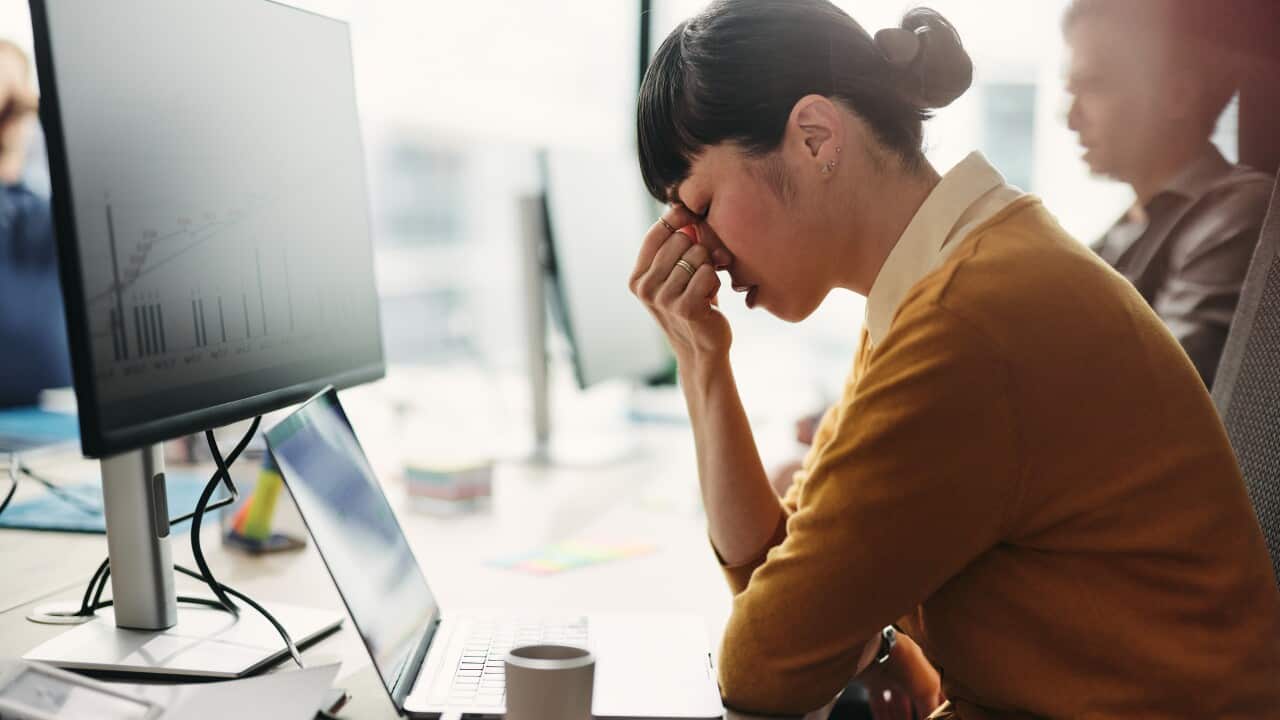 Japanese web designer having a headache while working on PC in the office.