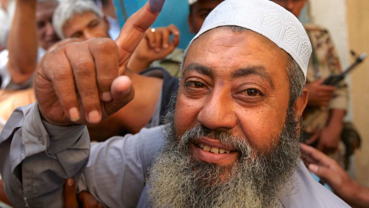 An Egyptian man holds up his inked finger in Old Cairo after voting in the presidential election. (AP)