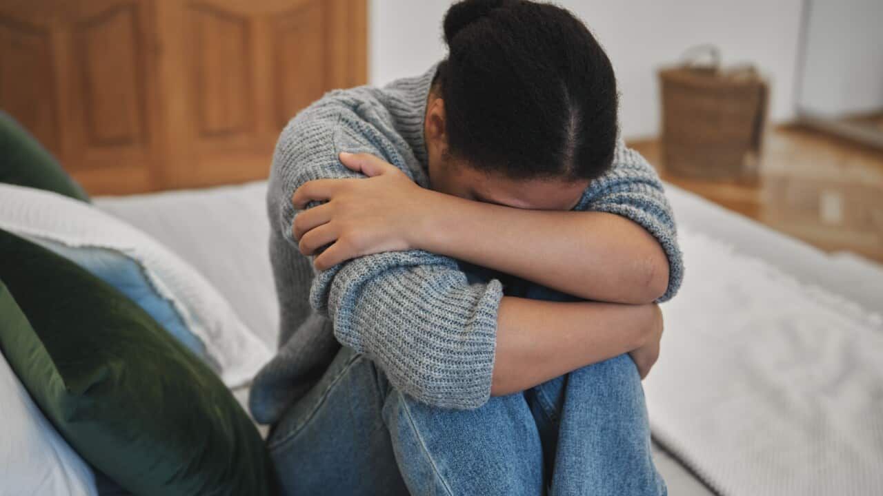 Sad depressed adolescent teen girl crying at home, worried teenager hugging knees suffering from depression, feeling lonely and upset, safrican american teen girl suffering from bullying