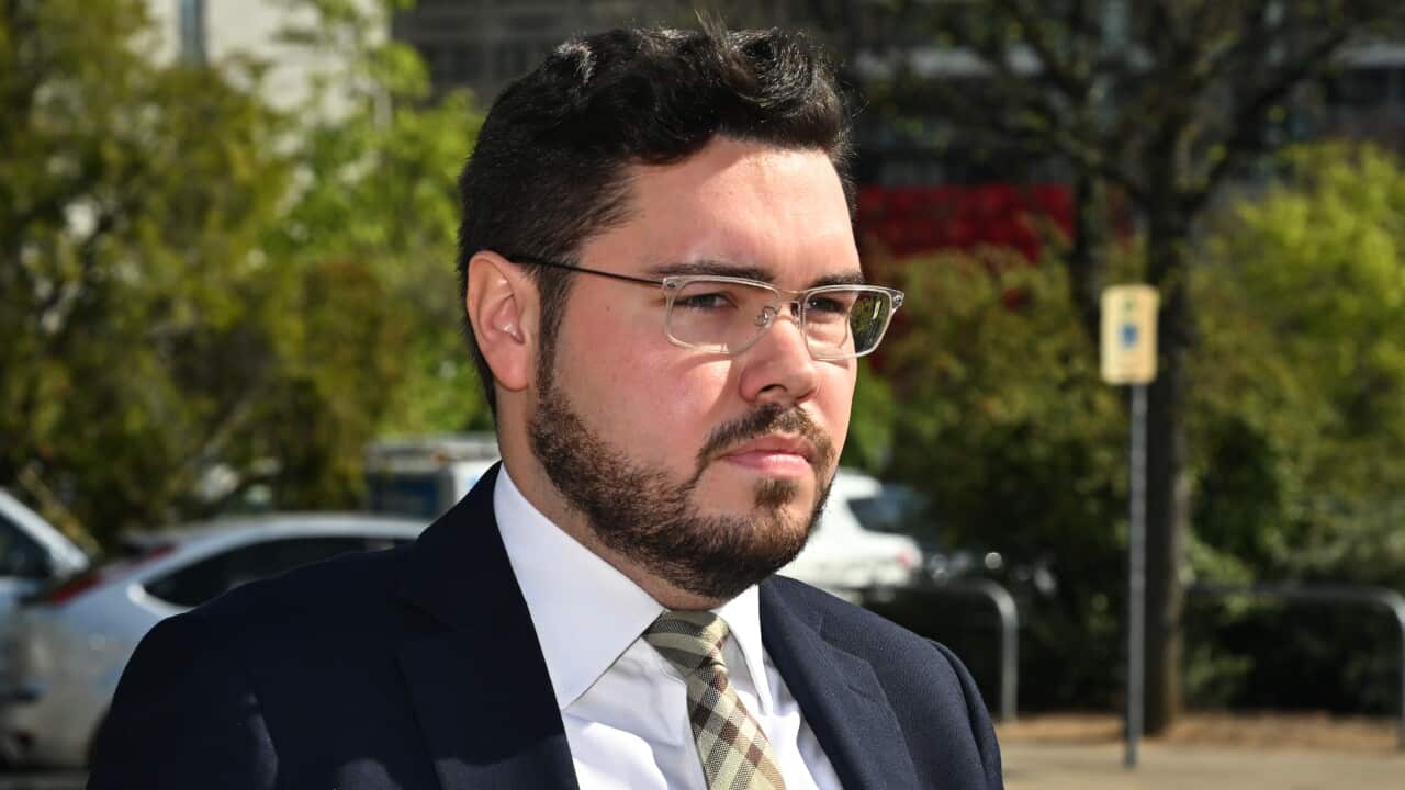A man wearing a suit, tie and glasses arrives at the ACT Supreme Court.