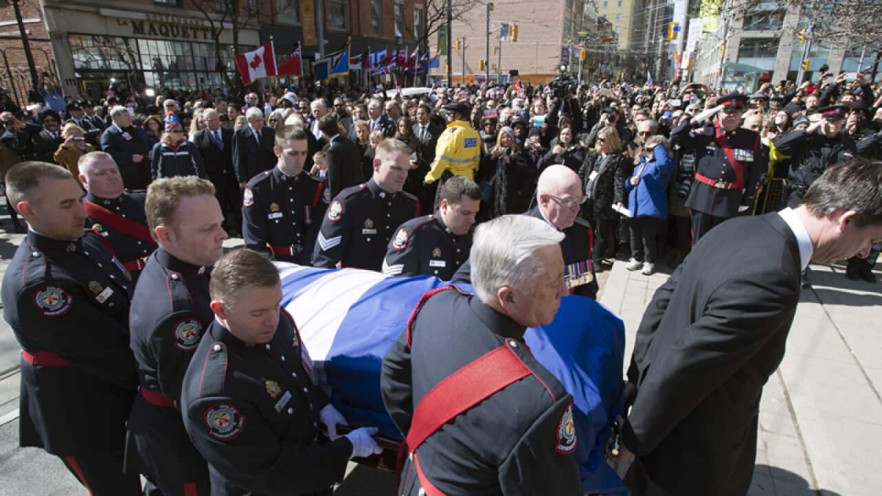 An honor guard carries the casket of Rob Ford into St. James Cathedral