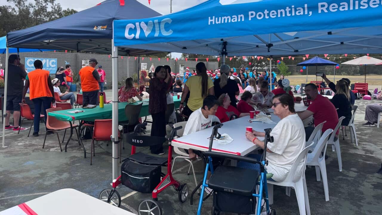 People seated around a lunch table outdoors.