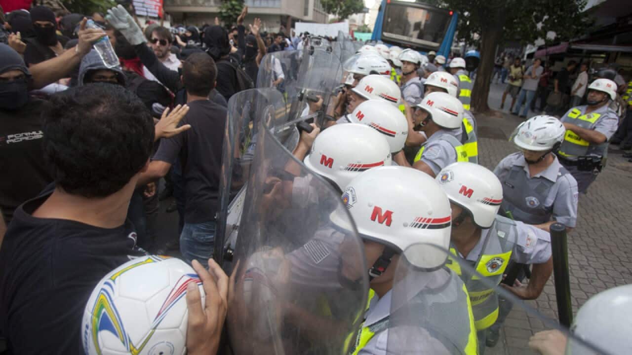 Military policemen block demonstrators during a World Cup protest