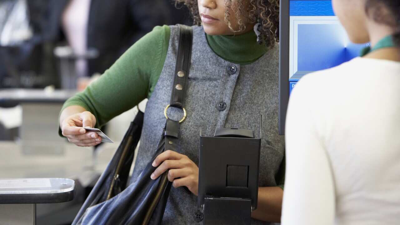 African woman looking at credit card