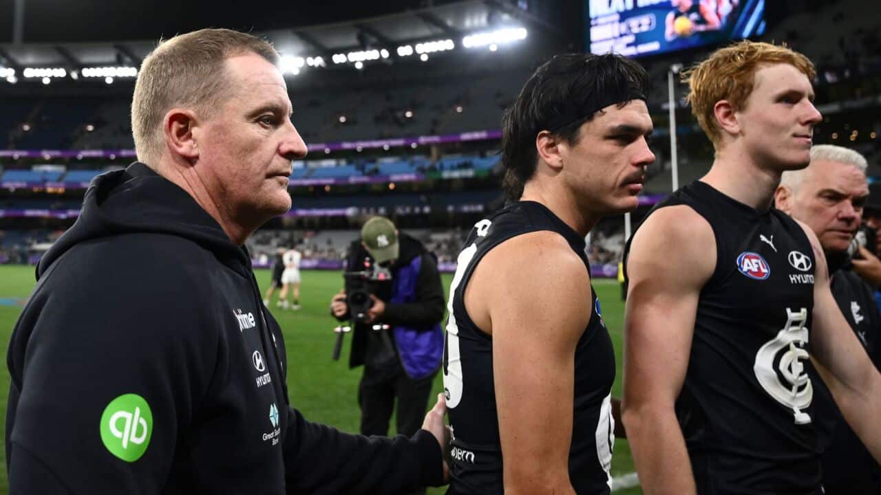 Carlton Blues head coach Michael Voss (left) and Elijah Hollands of Carlton (centre) leave the field following the AFL Round 6 match (AAP Image-Joel Carrett).jpg