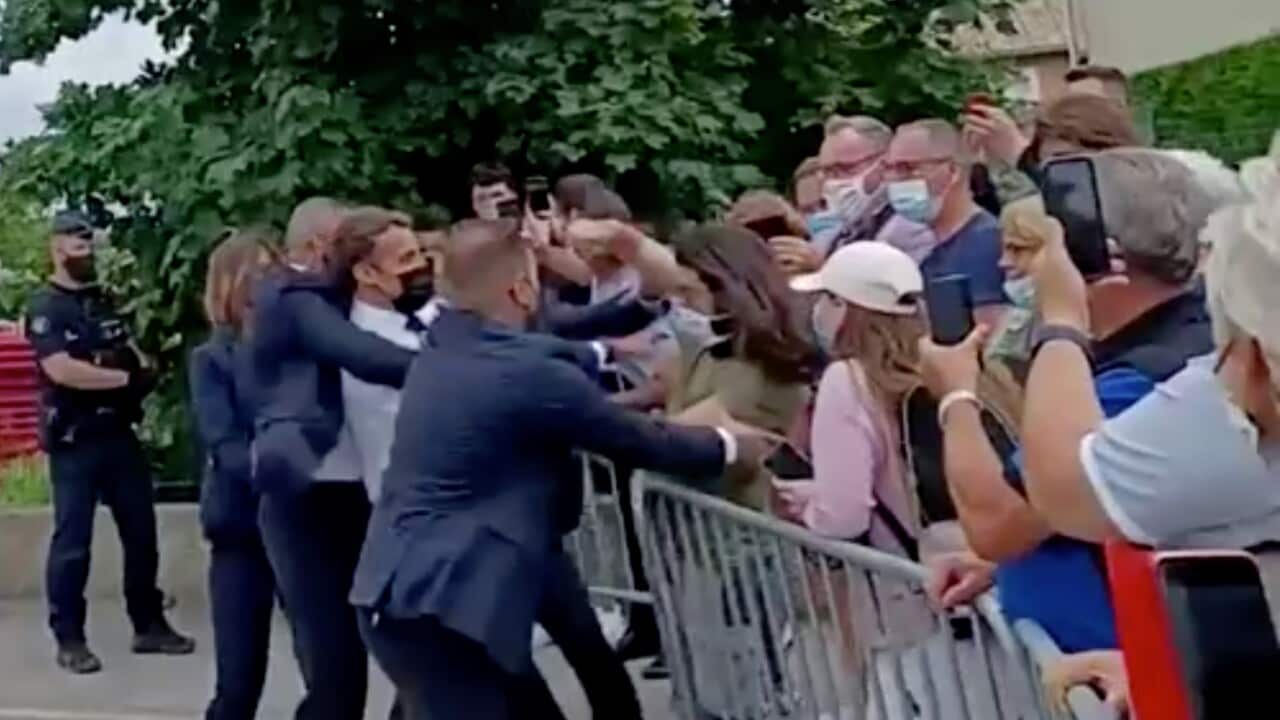 French President Emmanuel Macron is slapped in the face by a member of the public during a visit to Tain-l'Hermitage, France