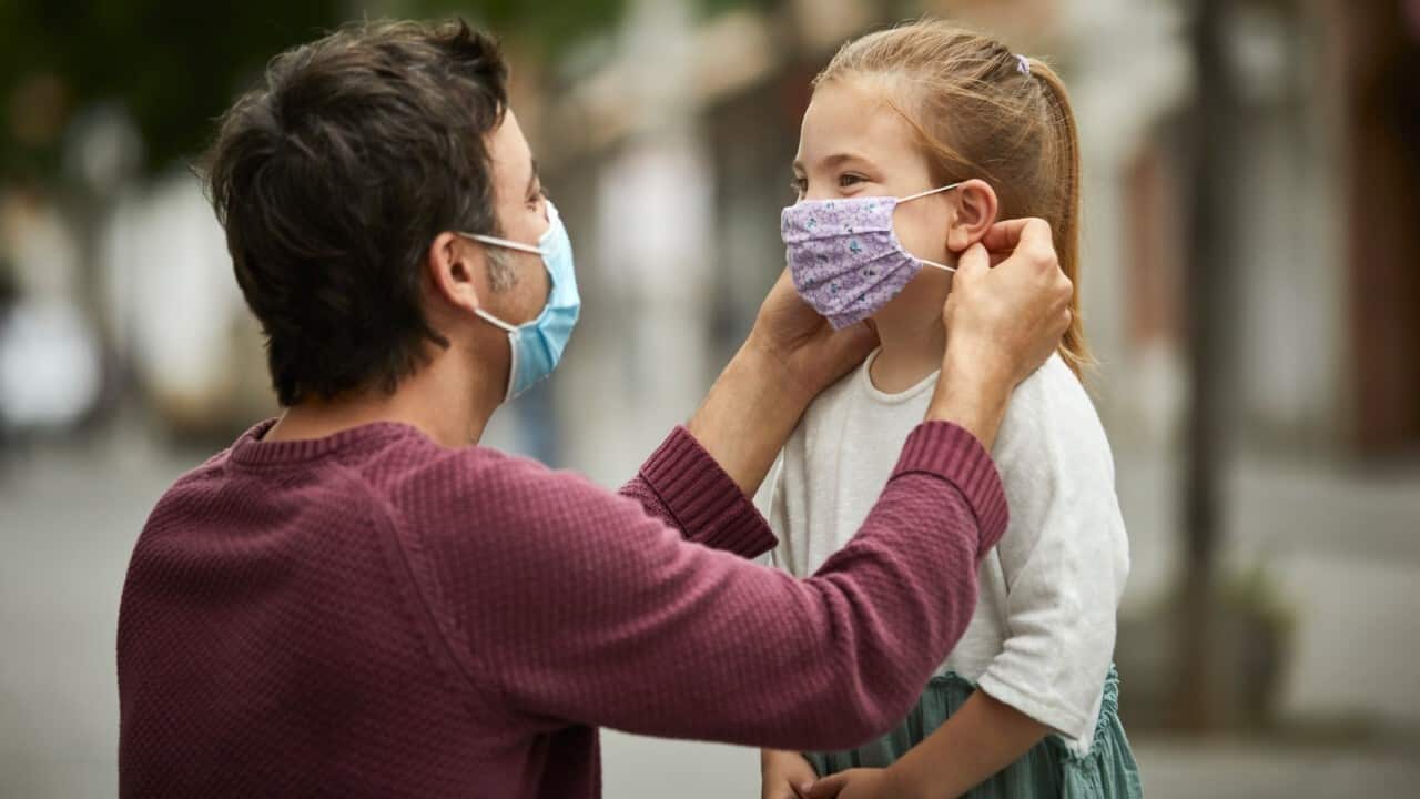 Father helps daughter with mask - Getty Images - Morsa