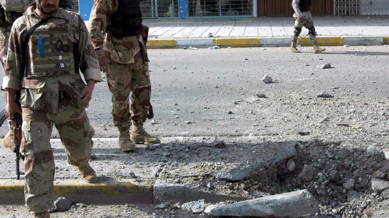 Iraqi soldiers secure the scene of a road side bomb