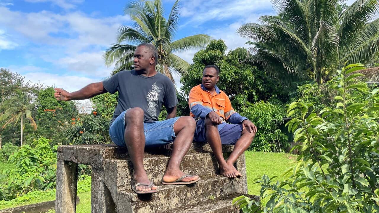Apete Vodivodi and Inoke Kasanibui sit on the remains of a removed house where flood waters have previously reached the top step (SBS-Jennifer Scherer).jpg