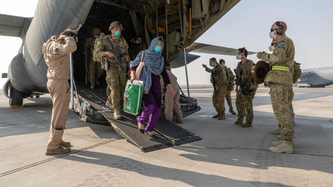 A supplied image from Friday, August 27, 2021, shows Afghanistan evacuees and soldiers disembarking at a base.