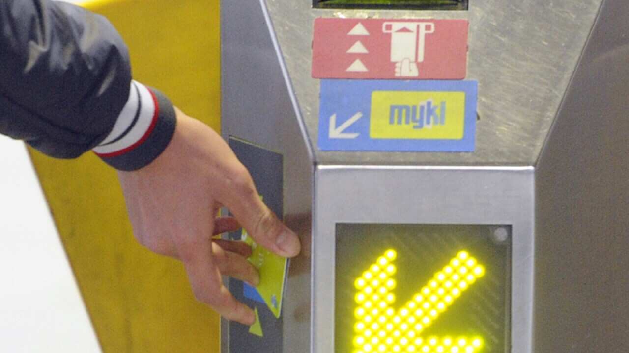 A public transport user swipes a MYKI Card