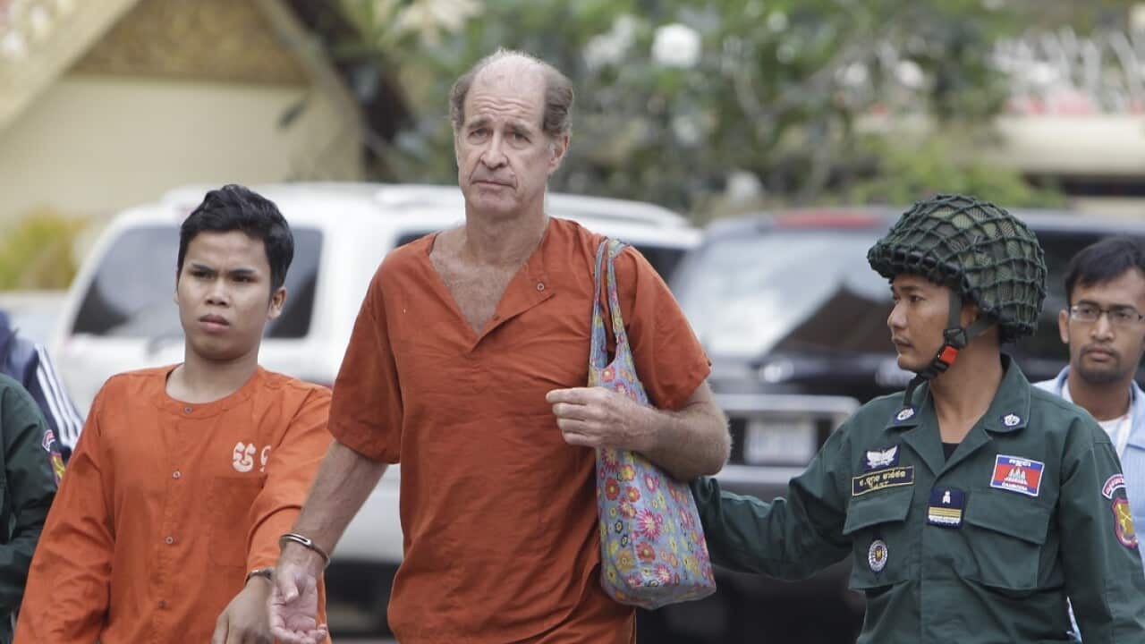Australian filmmaker James Ricketson is escorted by prison guards.