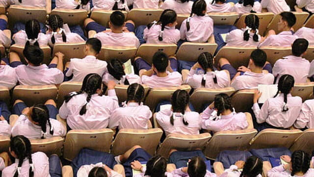 HK school children sitting in a school hall.