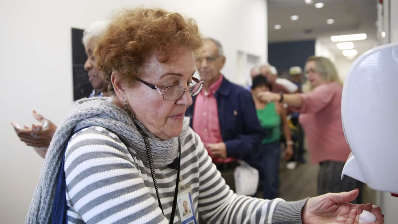 A woman uses hand sanitizer before eating lunch, as coronavirus poses a challenge for nursing homes and the elderly