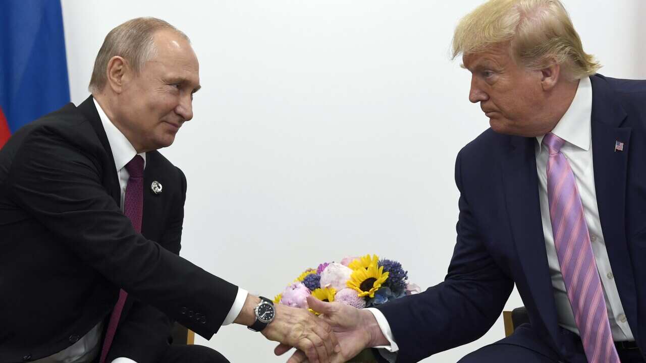Vladimir Putin and Donald Trump shaking hands.