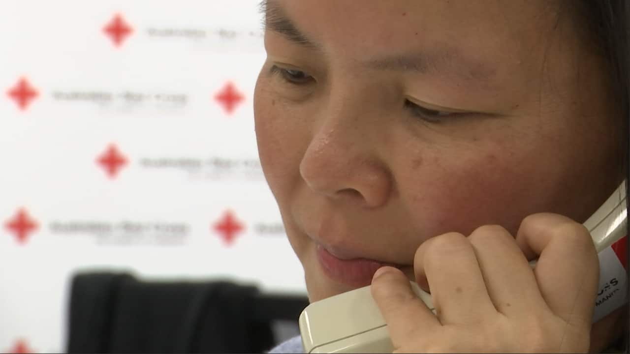 A volunteer calls elderly migrants in-language.