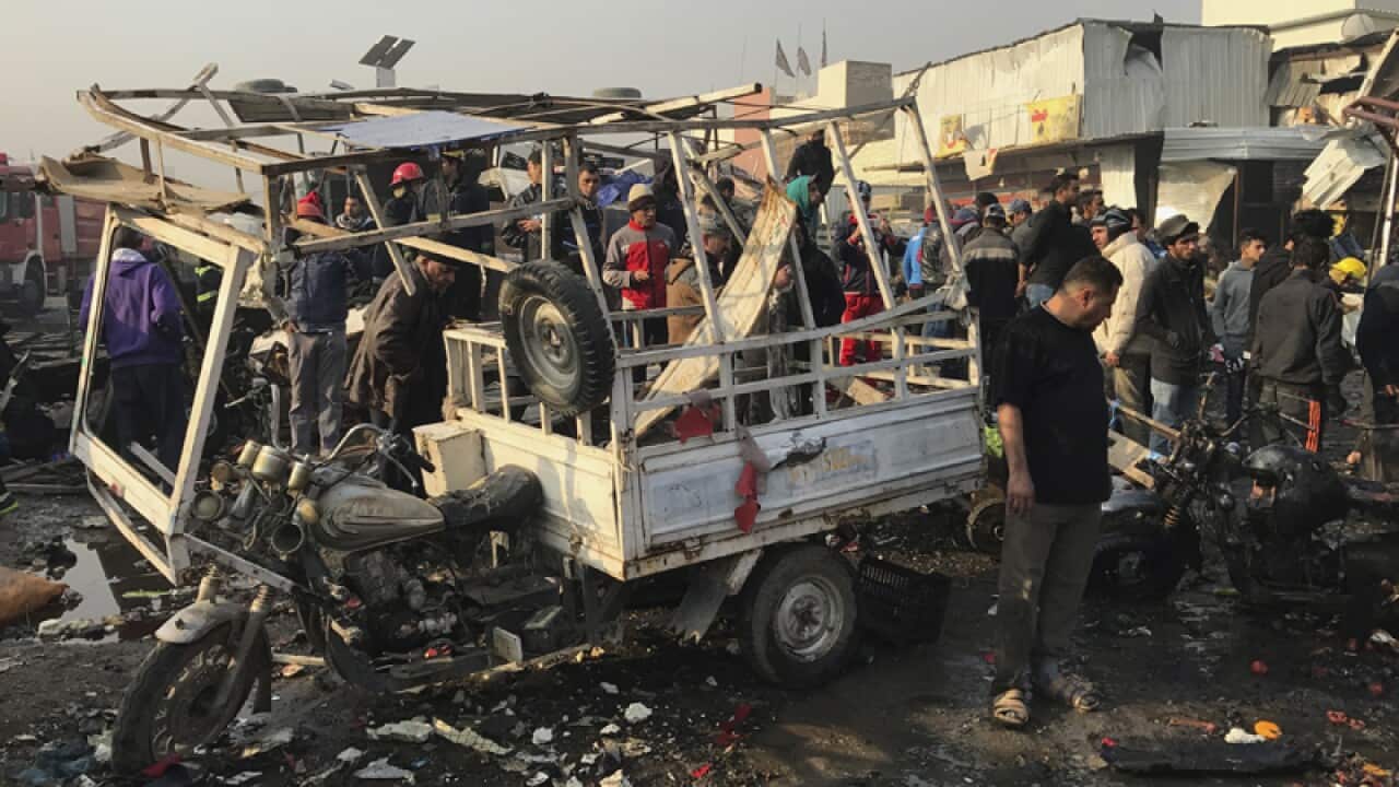 Citizens inspect the scene after a car bomb explosion