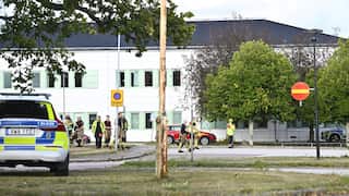 A white building in the background with police officers in the foreground.