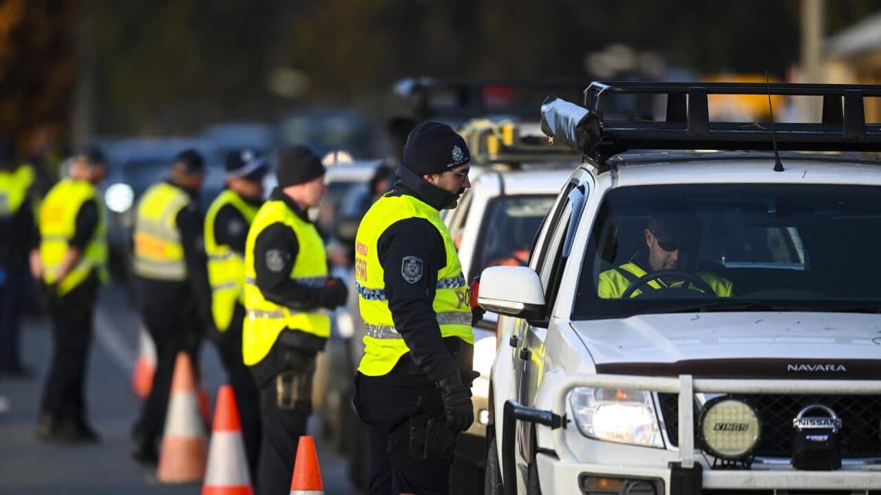 NSW Police officers check cars crossing from Victoria into New South Wales at a border check point in the NSW-Victoria border town of Albury.