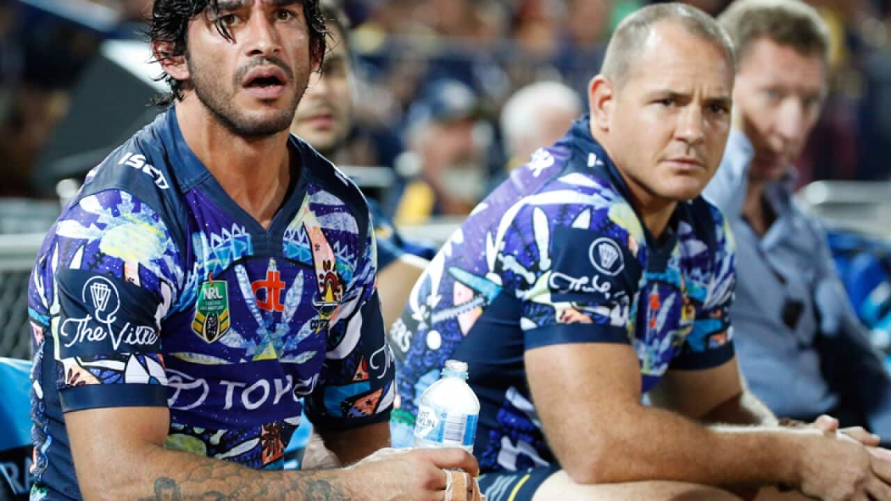 North Queensland captain Jonathan Thurston (L) sits on the bench