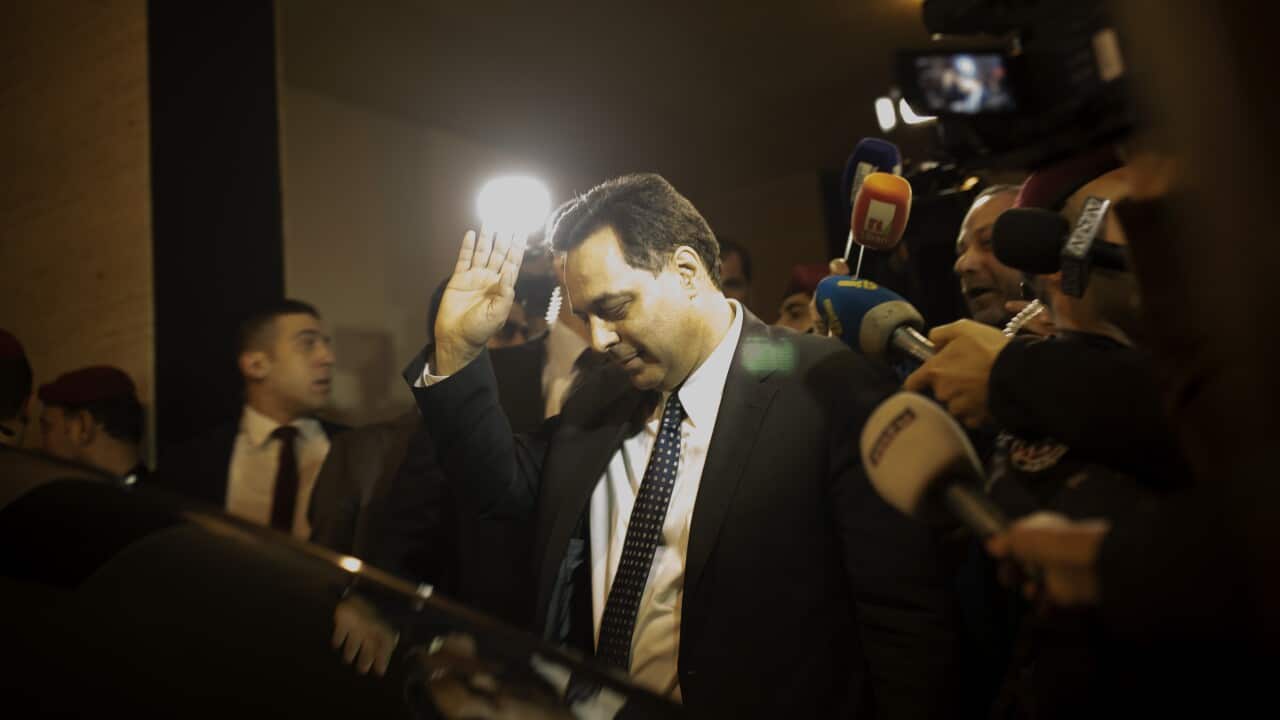 Newly-assigned Lebanese Prime Minister, Hassan Diab, gestures to journalists after arriving to his home following his meeting with President Michel Aoun.