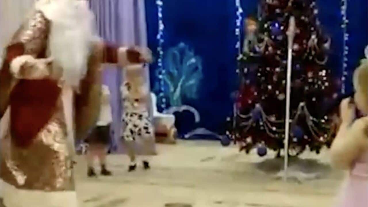 Santa Claus can be seen running around the room, much to the amusement of the children.