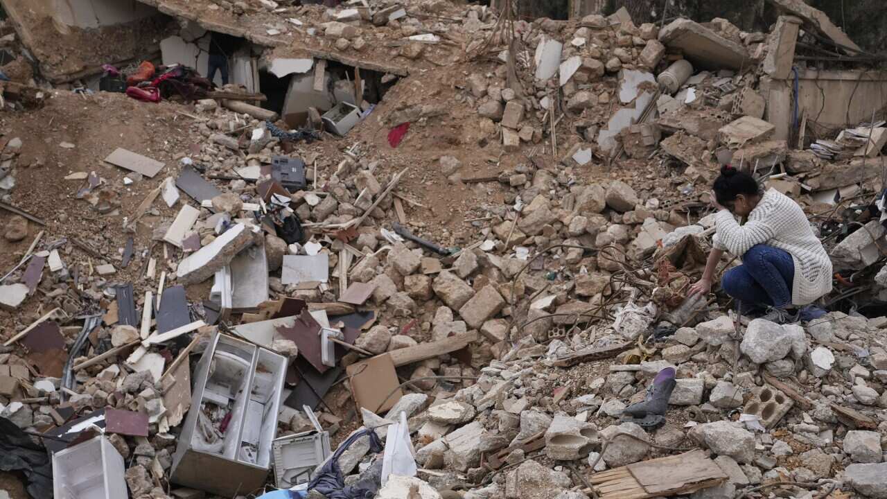 A man walks on the edge of the shell crater caused by a Russian missile strike