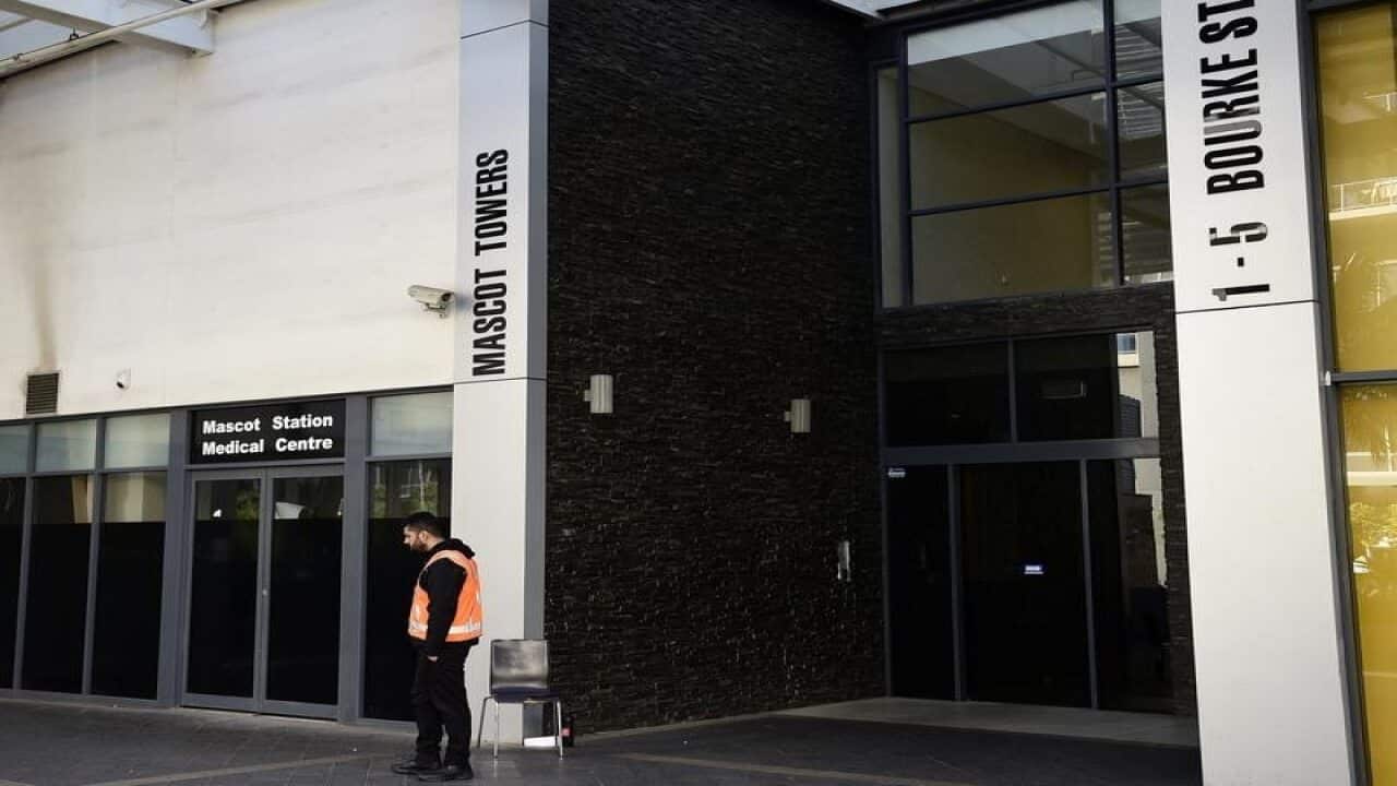A security guard outside the entrance of Mascot Towers.