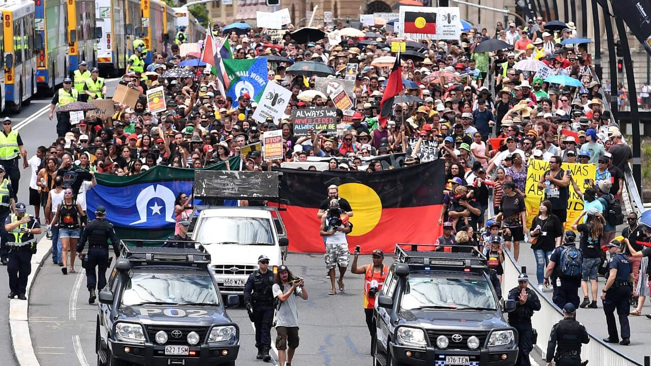 Indigenous protesters march through central Brisbane to protest what the call "Invasion Day" on Australia Day in Brisbane