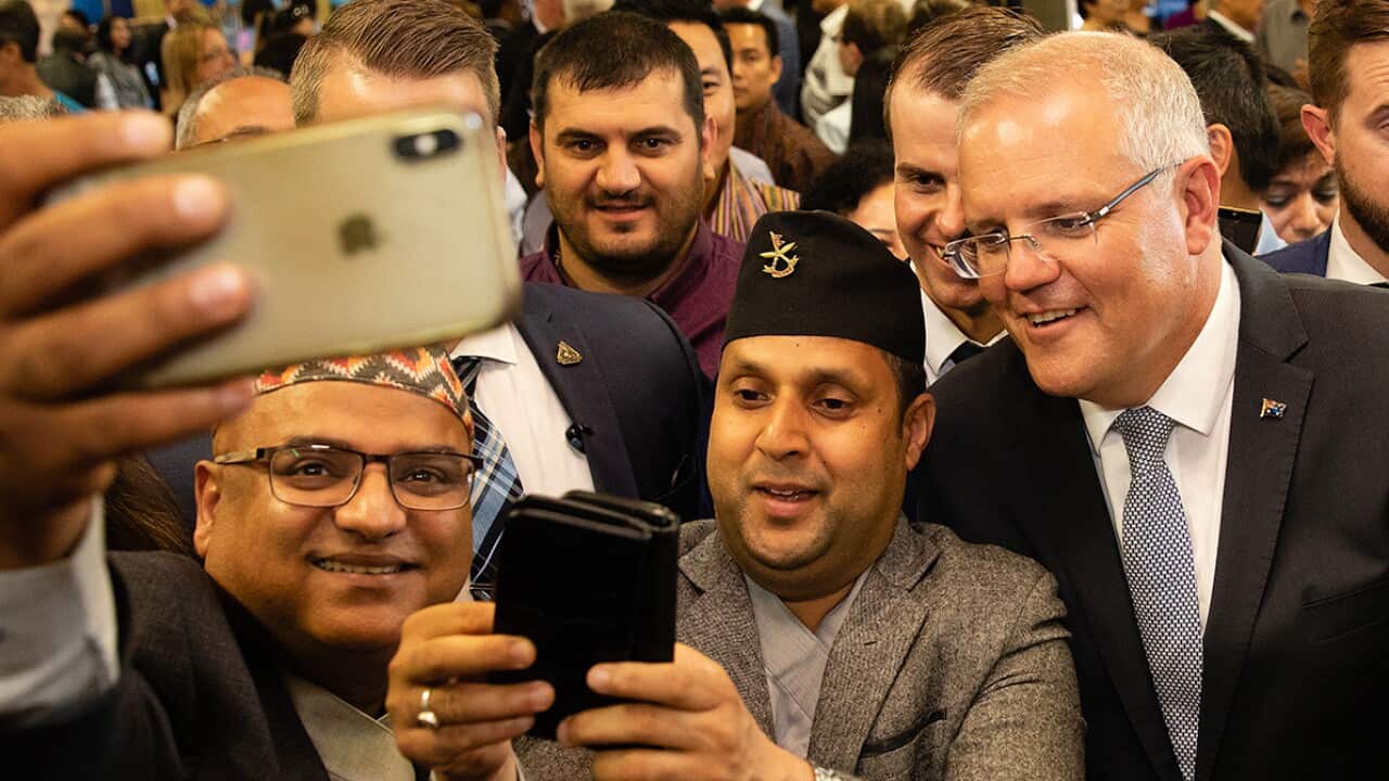 Australian Prime Minister Scott Morrison has a selfie taken with Nepali community members during a visit to the Koondoola Community Centre in Perth SBS