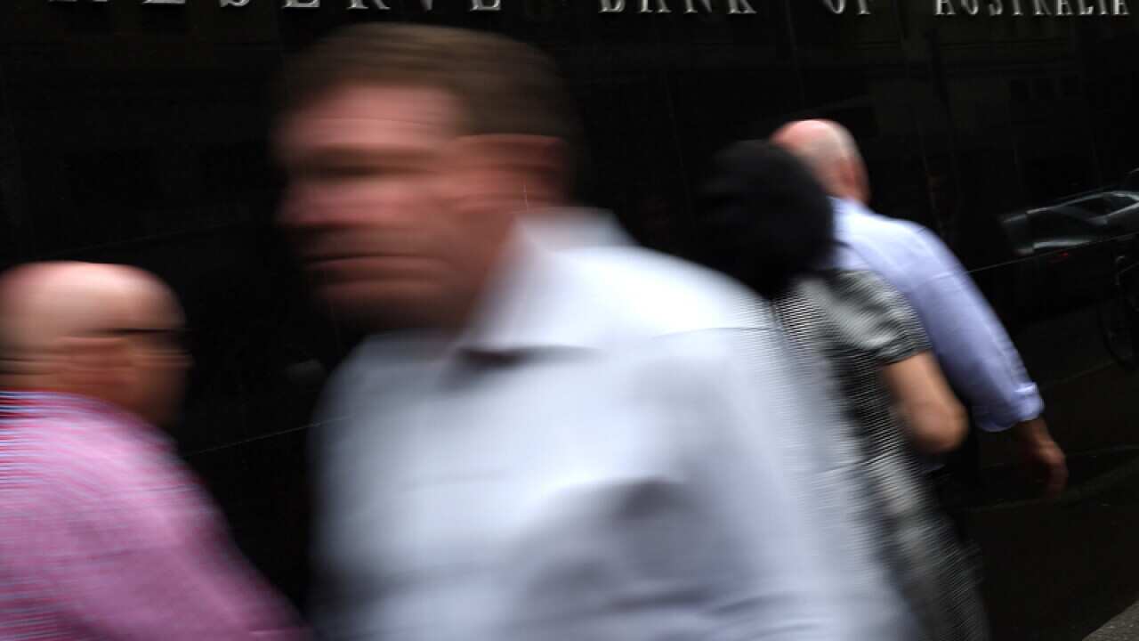 Pedestrians walk past the Reserve Bank of Australia