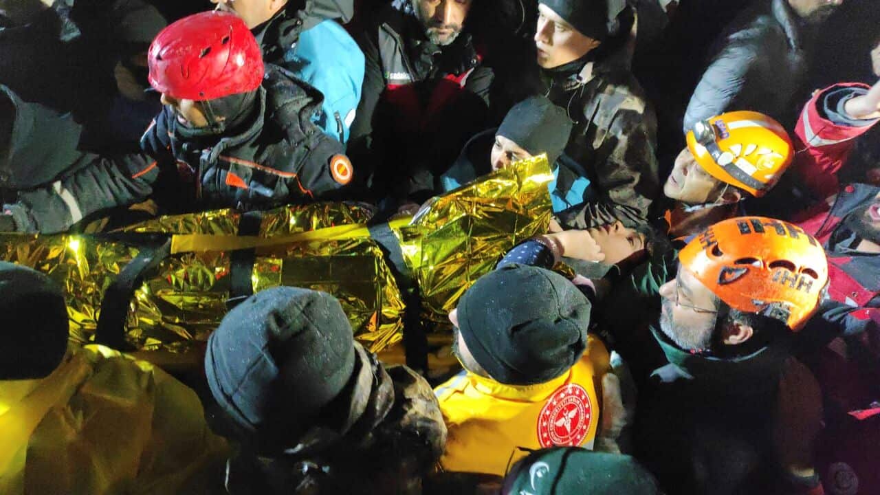 Rescue workers and medics carry a young woman they have rescued from the debris of a collapsed building in Sanliurfa, southern Turkey