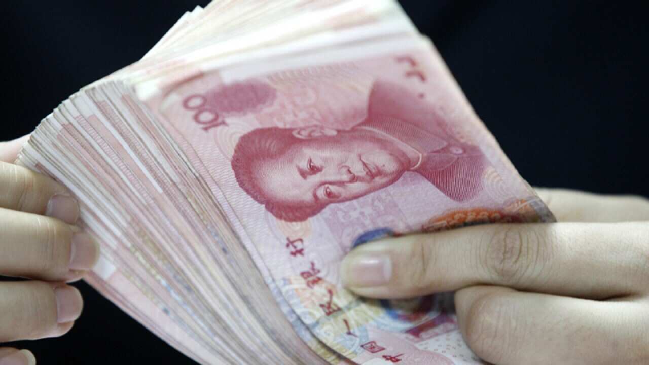 A Chinese clerk counts yuan bank notes
