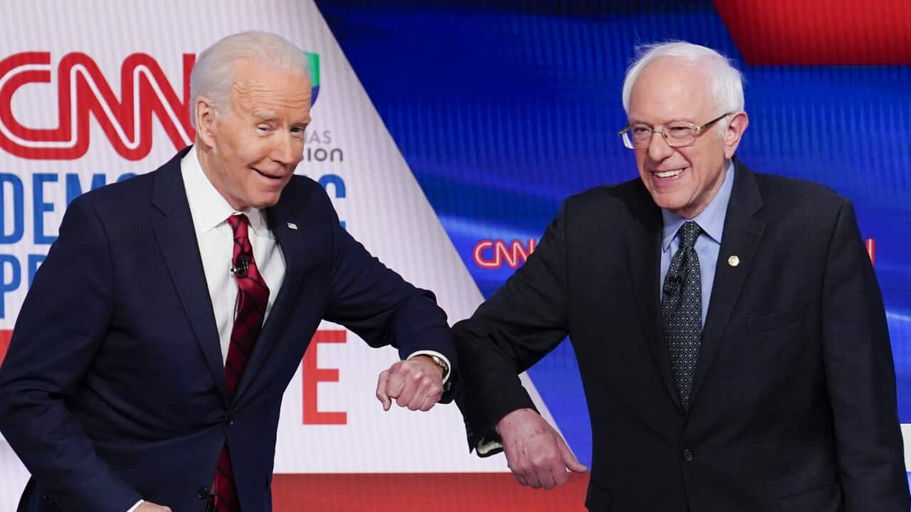Former Vice President Joe Biden and Senator Bernie Sanders greet each other before participating in a Democratic presidential primary debate.