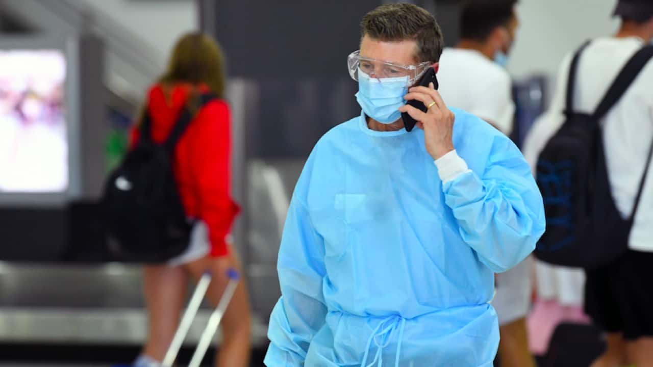 A person wearing personal protective equipment is seen in a baggage collection area at Tullamarine Airport in Melbourne, Friday, January 8, 2021