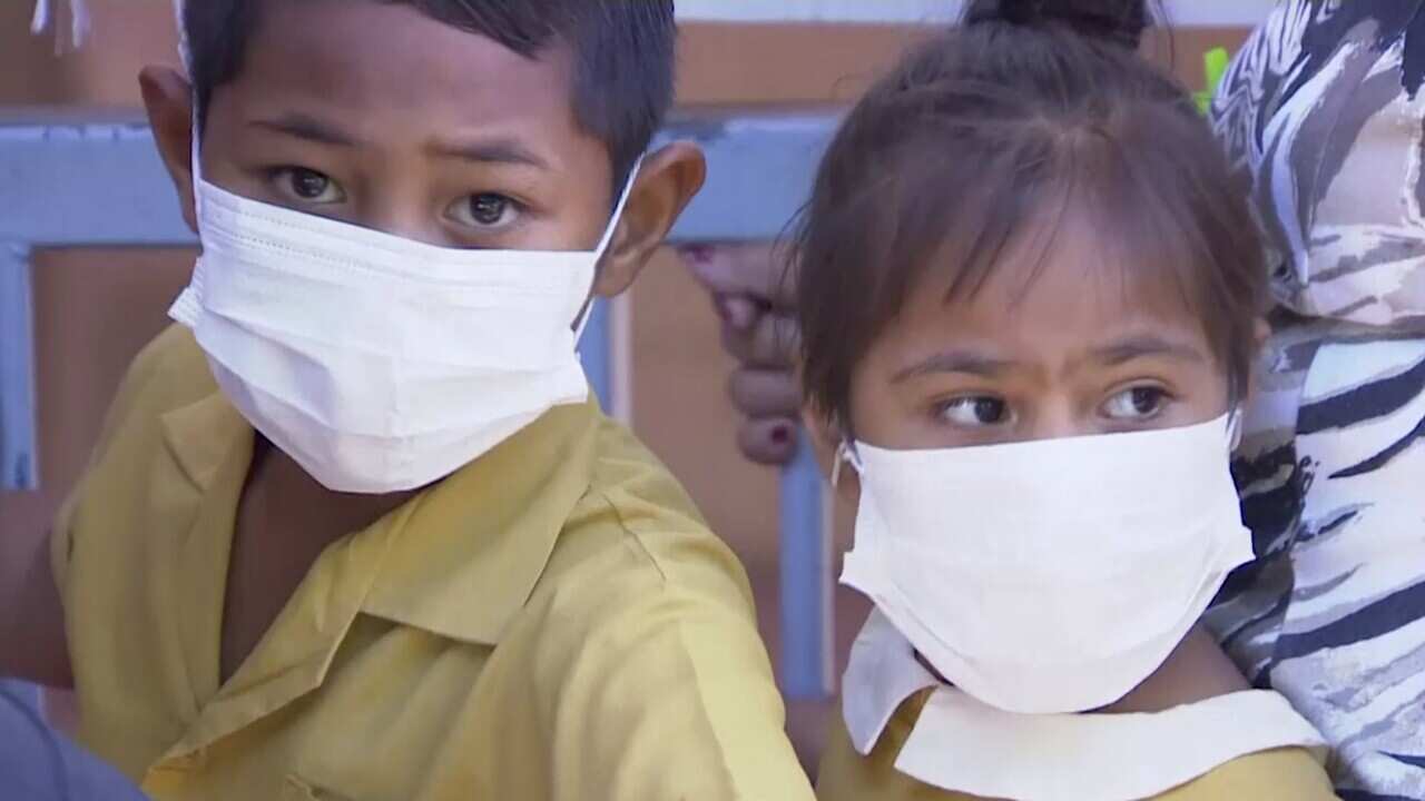 Masked children wait to get vaccinated at a health clinic in Apia, Samoa.