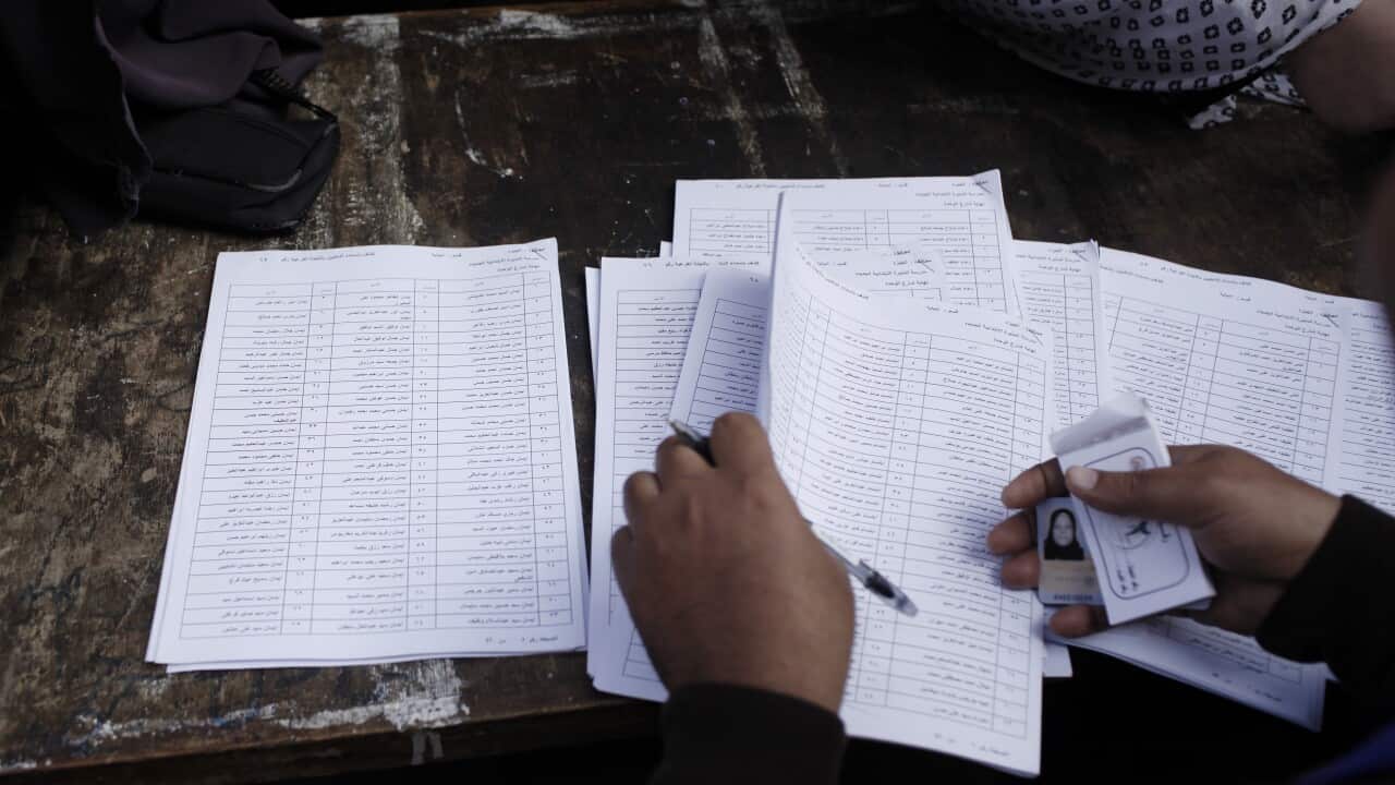 An Egyptian election official checks voters identification at a polling booth in Cairo getty.jpg