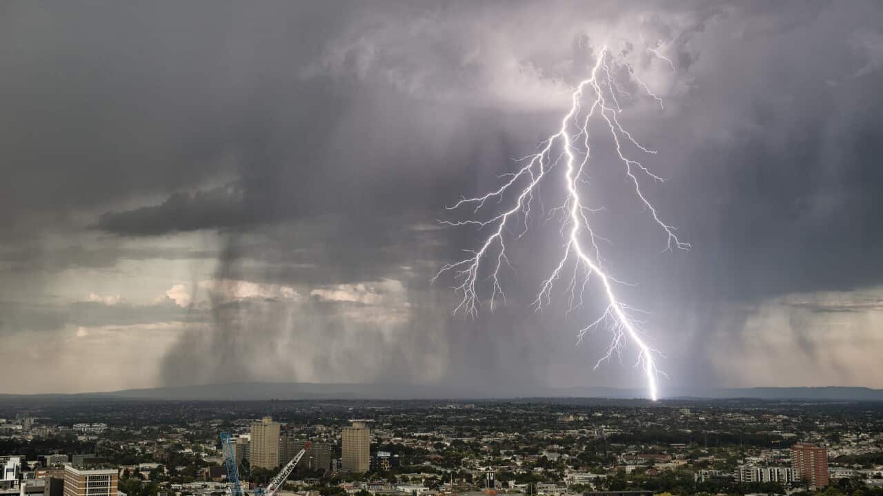 A lightning strikes against a grey sky backdrop over the city of Melbourne.