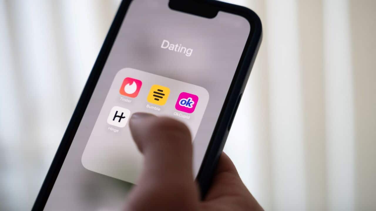 A woman holds a smartphone displaying dating apps (Alicia Windzio-dpa).jpg