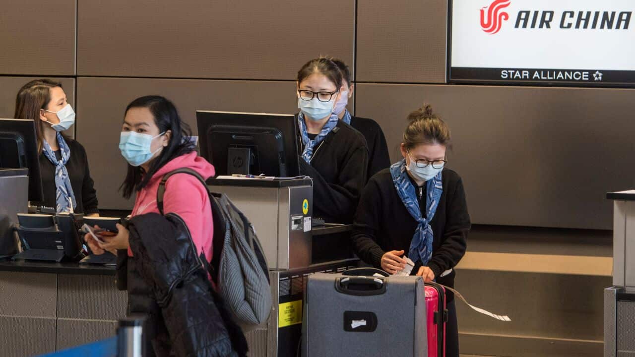 Chinese citizens wear face masks as they check in to their Air China flight to Beijing, at Los Angeles International Airport.