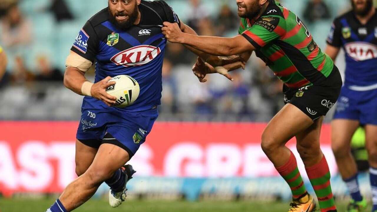 Sam Kasiano of the Bulldogs slips through a tackle against Rabbitohs.