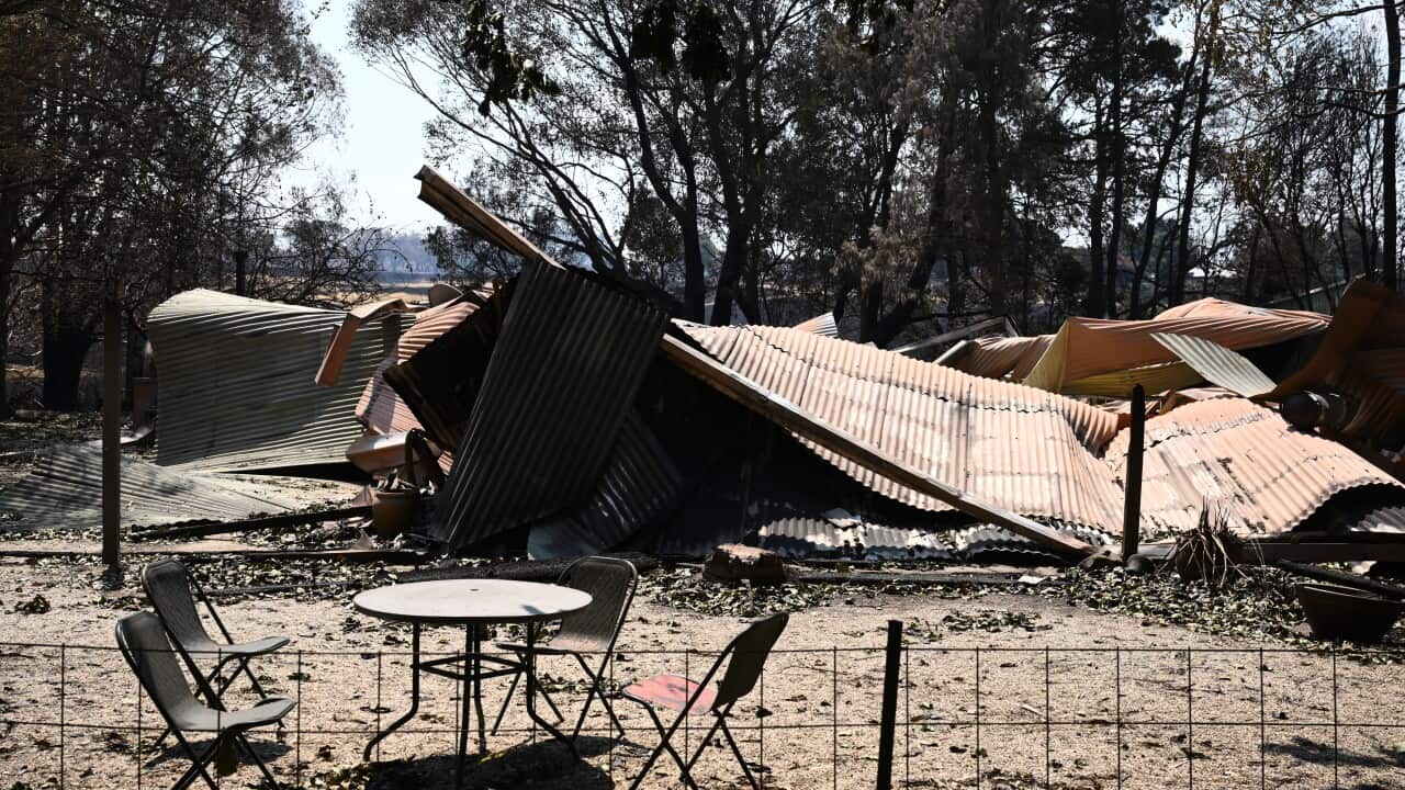 Charred corrugated iron on the ground after a building was destroyed by a bushfire