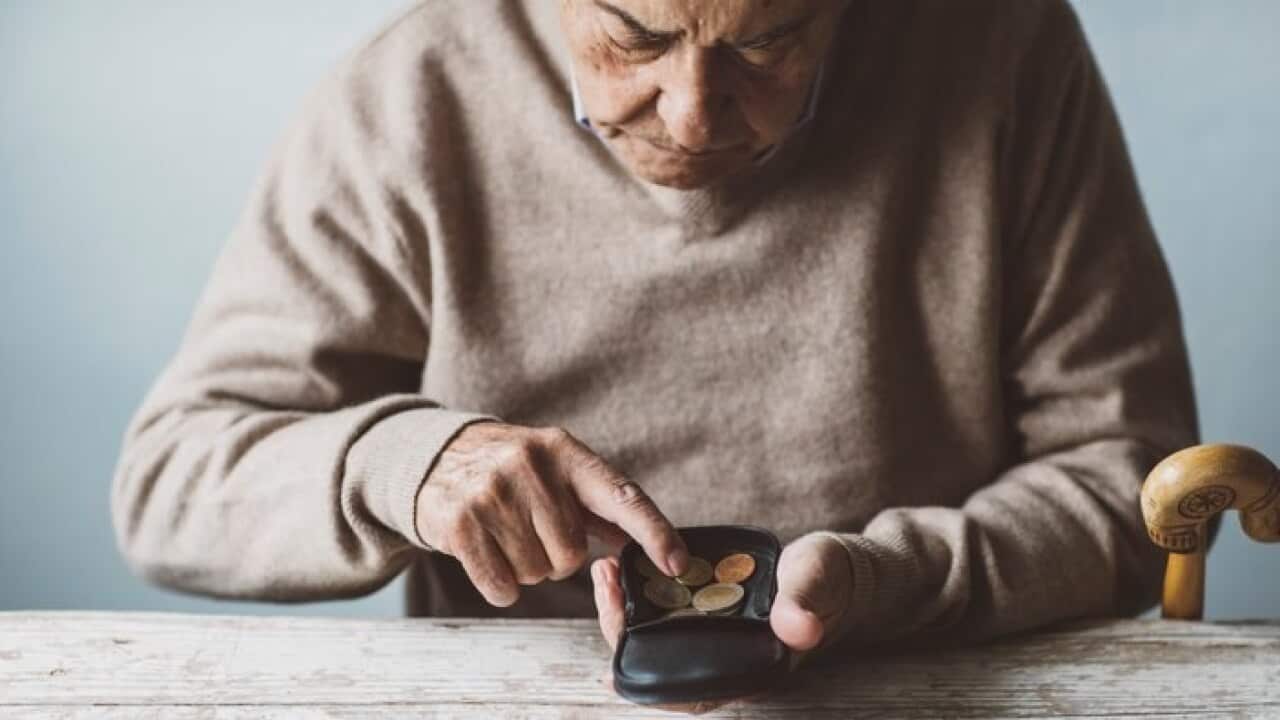 An elderly man look for some money from his wallet