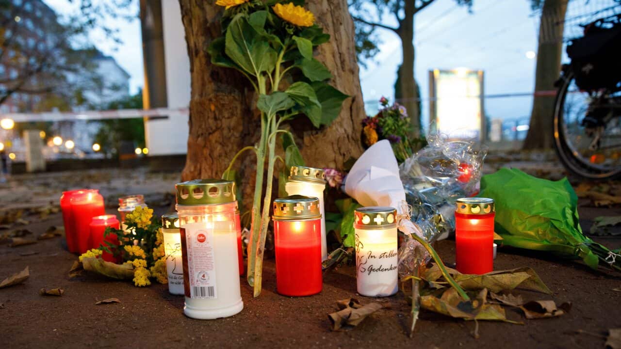 Candles and flowers are left near the crime scene where at least four people died in Vienna